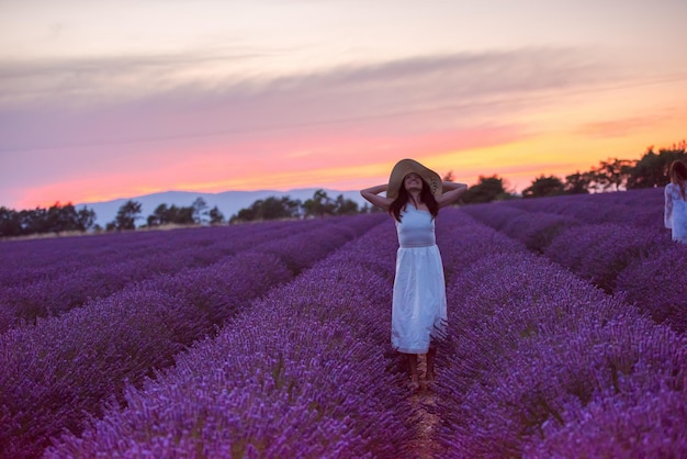 Frauenporträt im Lavendelblumenfeld bei Sonnenuntergang und Nacht