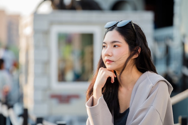 Frauenporträt junge thailändische Frauen, die am Abend einkaufen, Lebensstil für Frauenspaziergang im Sonnenuntergang am Flussufer, ehrliche Porträtfrau Bangkok, Thailand, Asien.