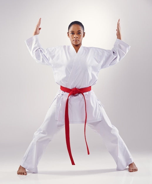 Frauenporträt und Hände für Karate im Studio Fitness und Kampfkünste auf weißem Hintergrund Schwarze Person Athlet und roter Gürtel für Taekwondo Disziplin und Krieger bereit für Selbstverteidigung oder Schlacht
