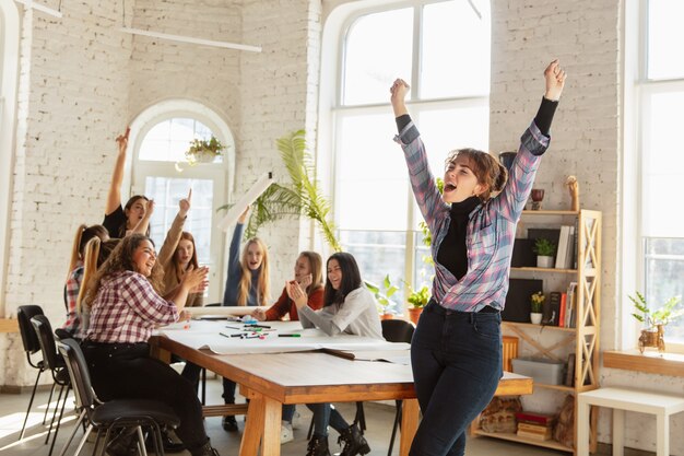 Foto frauenrechte und gleichberechtigung im büro. kaukasische geschäftsfrauen oder junge selbstbewusste models, die vor kollegen feiern, die sich über probleme am arbeitsplatz, männlichen druck und belästigung treffen.