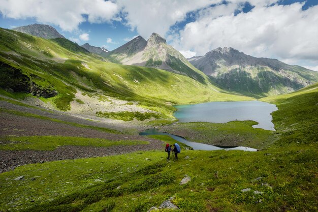 Frauenreisende mit Rucksack und Blick auf erstaunliche Berge und Seereisen im Naturkonzept