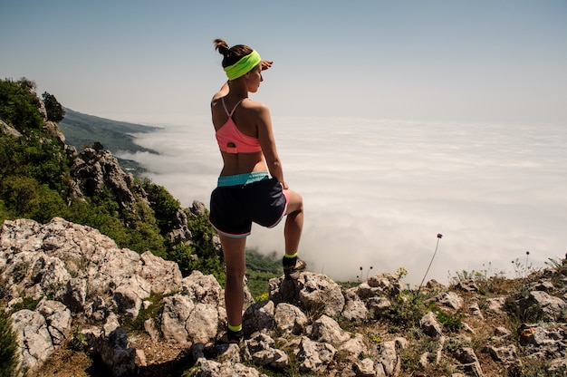 Frauenreisender auf Berggipfel über Wolken Reiselebensstil