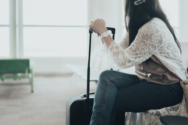 Frauenreisender, der allein im Flughafen sitzt
