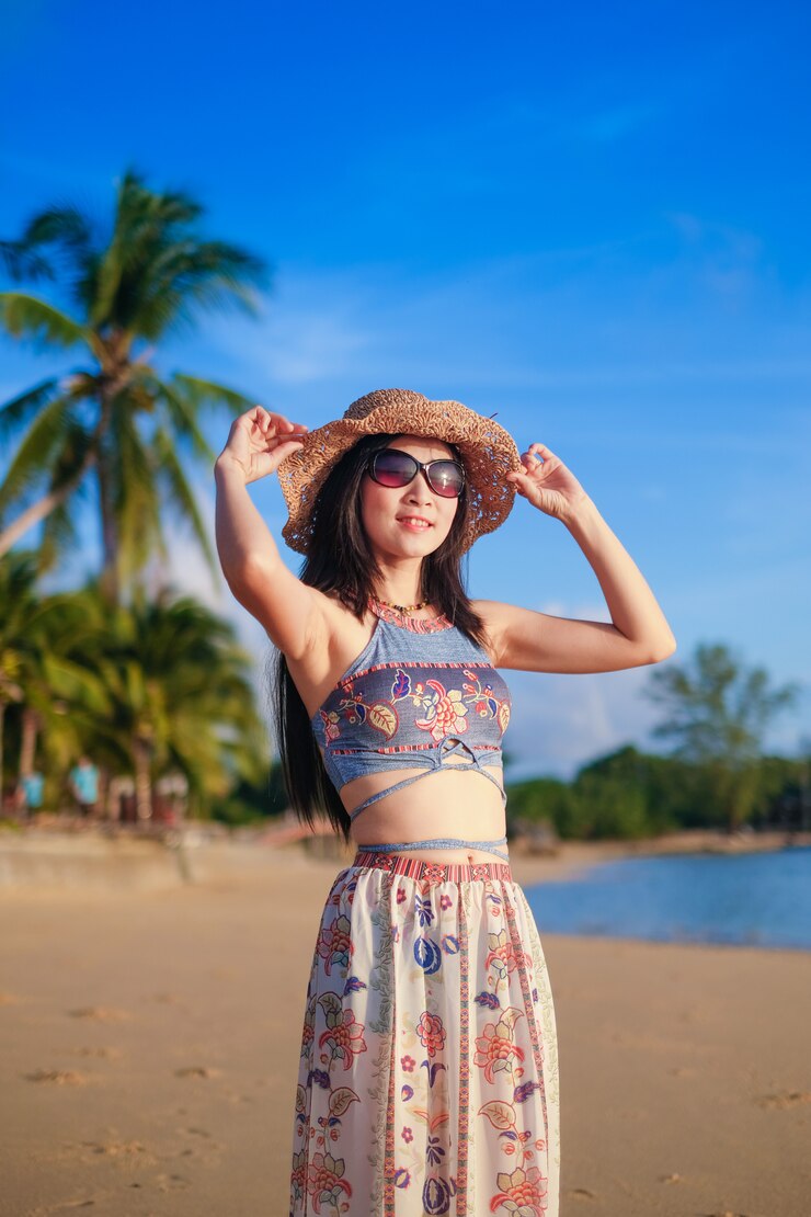 Frauenreisender, der auf dem Strand steht und für Ansicht des Meeres im Urlaub genießt.