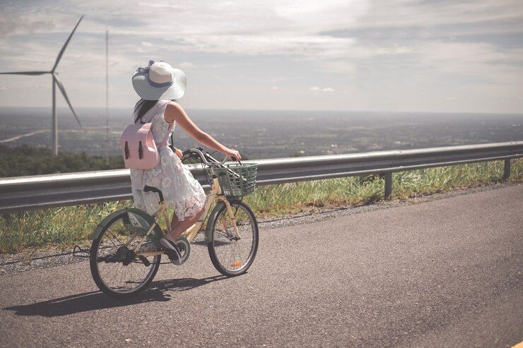 Frauenreisender, der Fahrrad fährt und Fotoansicht des Dammes macht