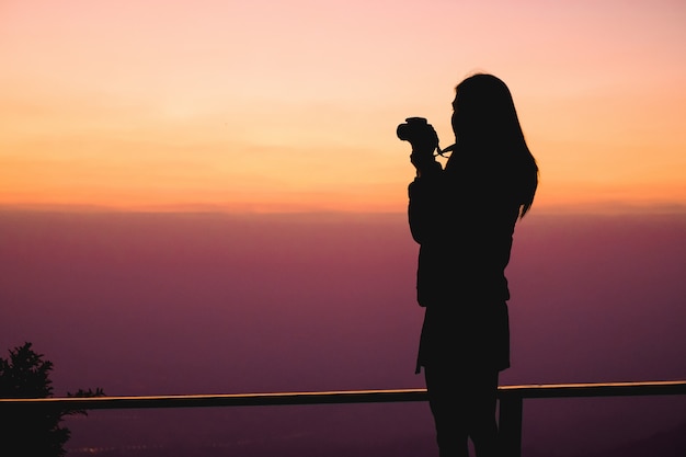 Foto frauenreisender, der oben auf dem berg steht und fotoansicht der natur im urlaub nimmt.