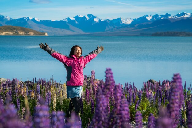 Frauenreisender in See Tekapo, Neuseeland. Lupineblume in See Tekapo schlug volle Blüte im Dezember.