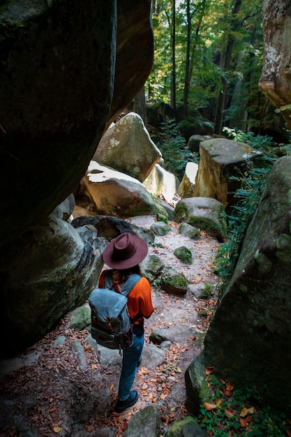 Frauenreisender mit Rucksack, der durch die Schlucht geht