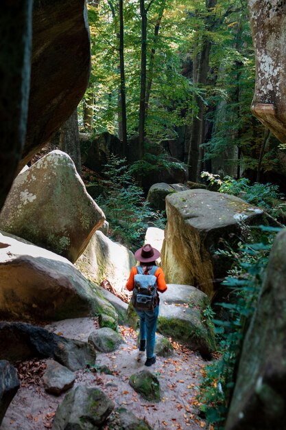 Frauenreisender mit Rucksack, der durch die Schlucht geht