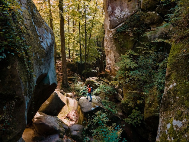 Frauenreisender mit Rucksack, der durch die Schlucht geht