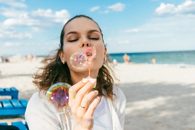 Frauenschlagblasen auf dem Strand im Sommer