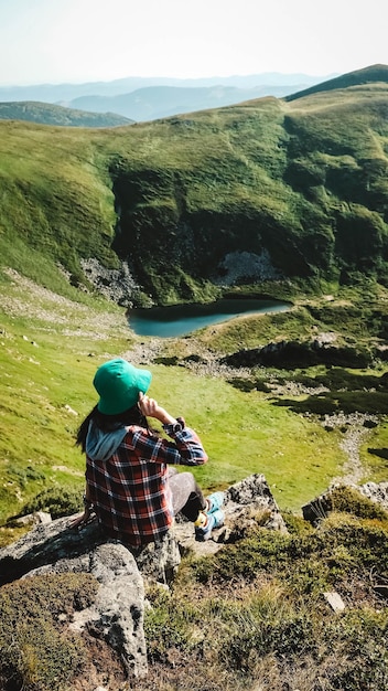 Frauentourist auf Hintergrund von grünen Bergen und von See