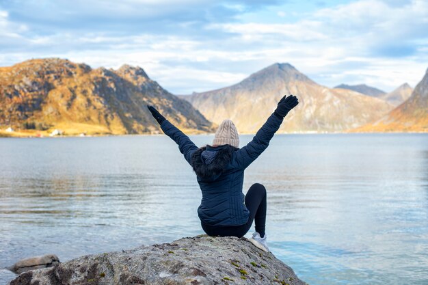 Frauentourist, der auf Felsen in Norwegen-Landschaft sitzt