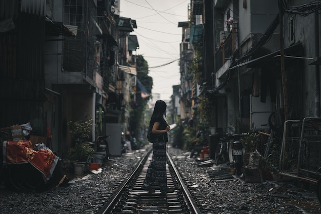 Frauenwanderer, der auf einer Bahngleis in Hanoi Vietnam steht