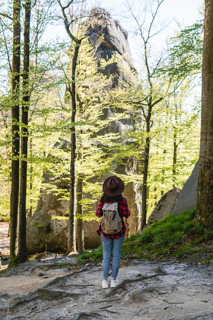 Frauenwanderer mit Rucksack, der am Waldweg-Kopienraum spazieren geht