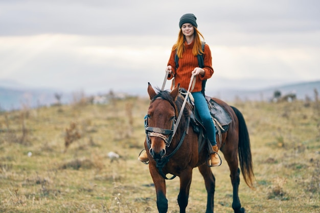 Frauenwanderer reitet auf einem Pferd auf der Natur in den Bergen