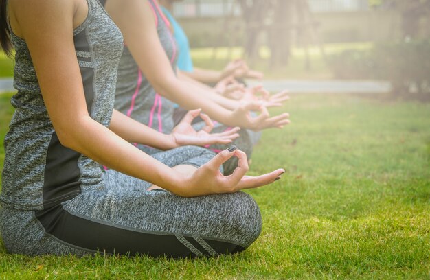 Frauenyoga entspannen sich in einem Park.