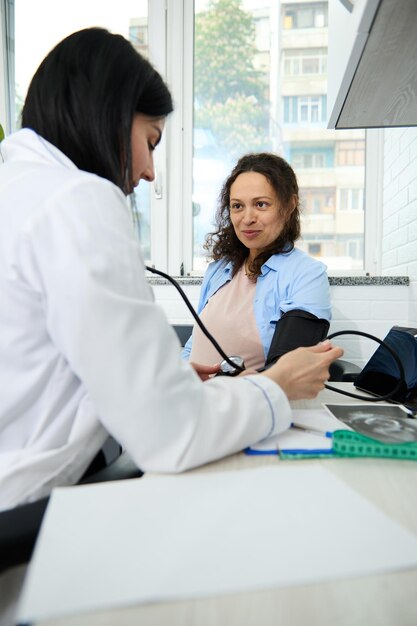 Foto frauliche ärztin untersucht einen patienten im büro