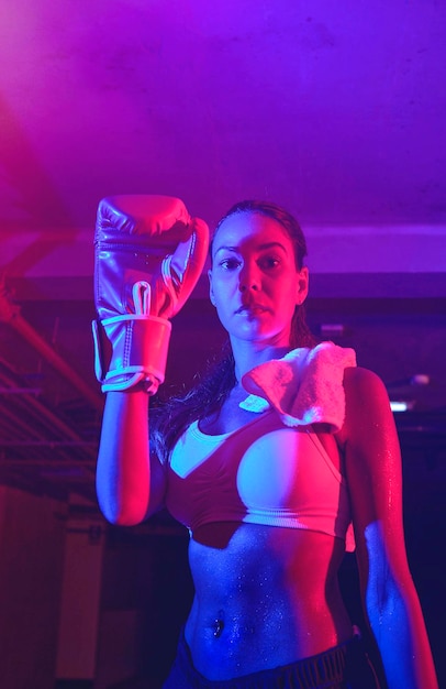 Frauliche Boxer-Training rote Boxhandschuhe Ring mit roten und blauen Lichtern Industrielle Fitness-Neonlichter