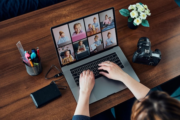 Frauliche Fotografin arbeitet an Fotos auf Laptop und Kamera Frau bearbeitet, retuschiert, durchsucht Fotos