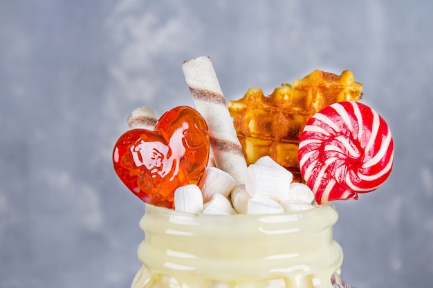 Freakshake de batido rosa, creme. Monstershake com pirulitos, waffles e marshmallow.