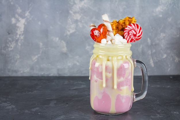 Freakshake de batido rosa, creme. Monstershake com pirulitos, waffles e marshmallow.