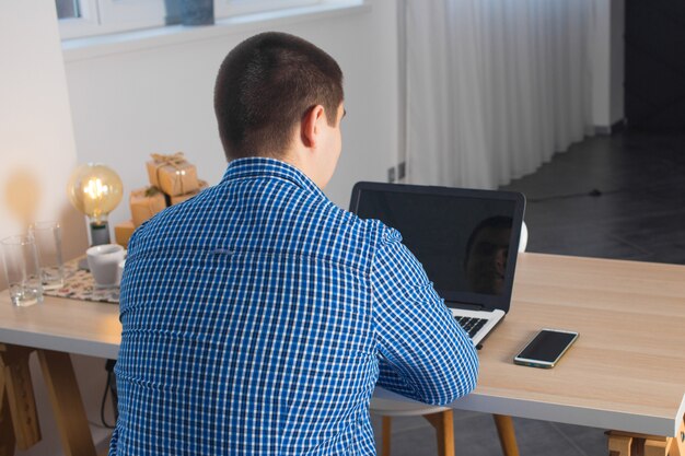 Foto freelance masculino está trabajando con una computadora portátil en casa