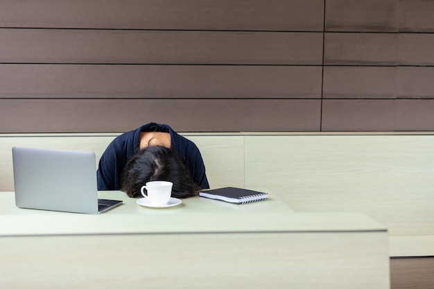 Freelancer cansado durmiendo en la mesa en el café