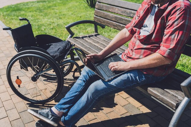 Freelancer com deficiência física em cadeira de rodas e que trabalha no parque