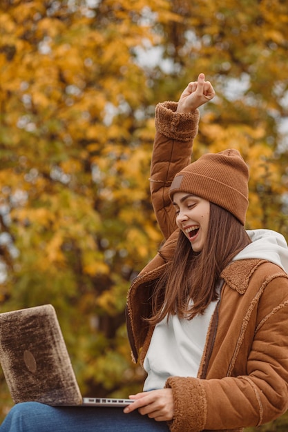 freelancer comemorando o sucesso e expressando triunfo enquanto cerra o punho e trabalha no laptop