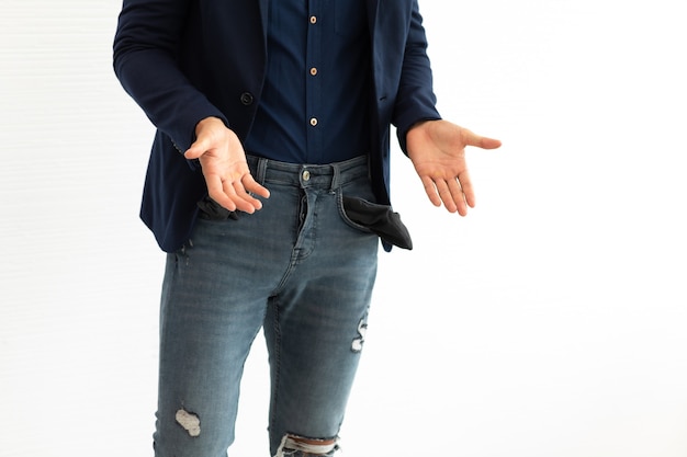 Freelancer de homem de negócios latino-americanos jovem mostrando seus bolsos vazios em pé sobre fundo branco.