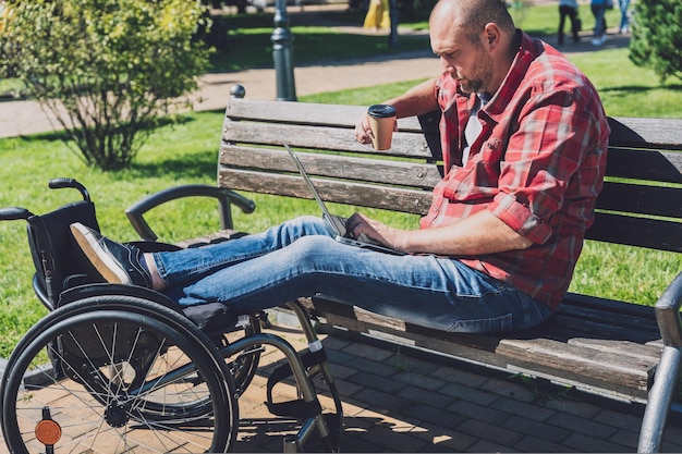 Freelancer con discapacidad física que usa silla de ruedas trabajando en el parque