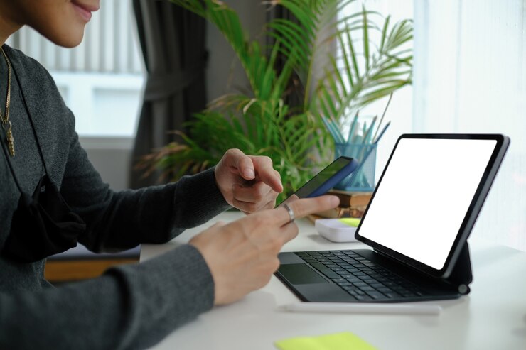Foto freelancer hombre trabajando en línea con tableta y usando teléfono móvil.