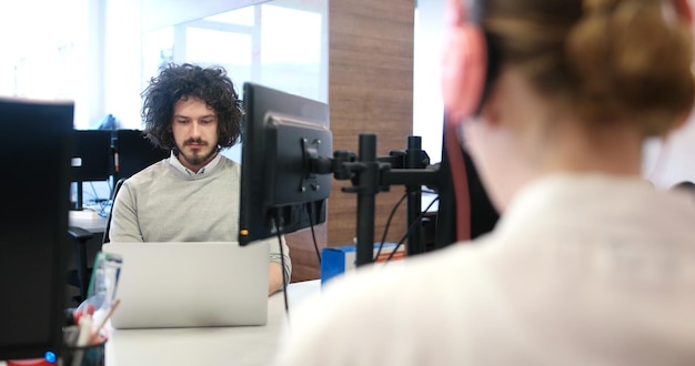 Freelancer jovem empreendedor trabalhando usando um laptop no espaço de coworking