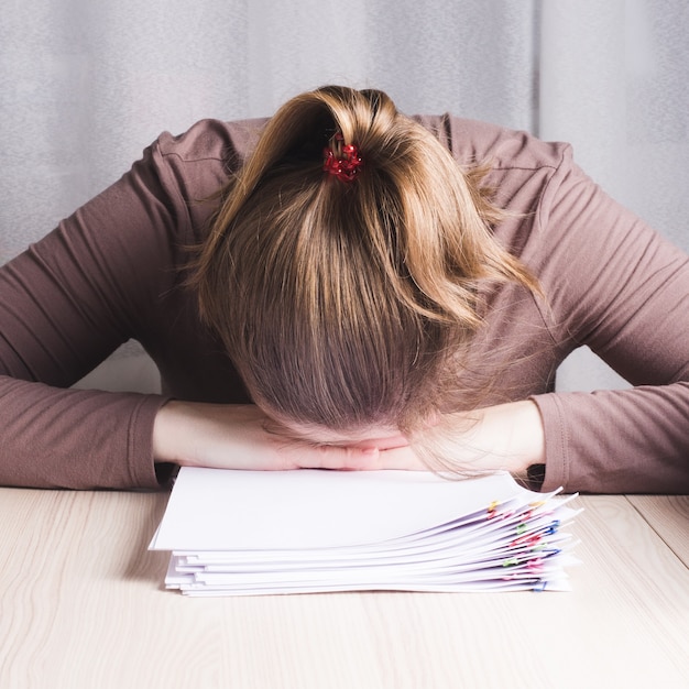 Freelancer joven cansada en casa escritorio de oficina durmiendo