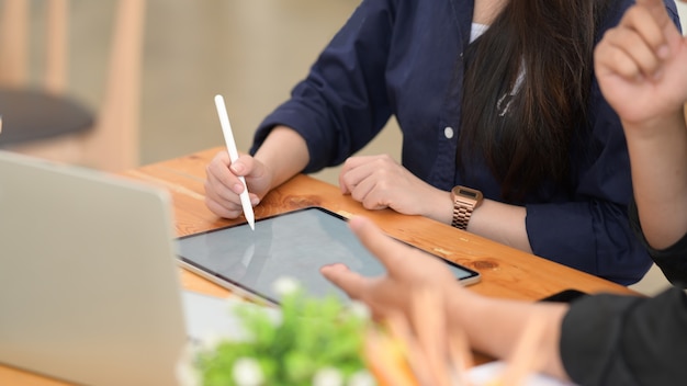 Freelancer masculino y femenino usando tableta digital en la oficina