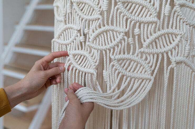 Foto freelancer mujer trabajando en pieza de macramé a medio terminar, teje pantalla de lámpara para lámpara de araña