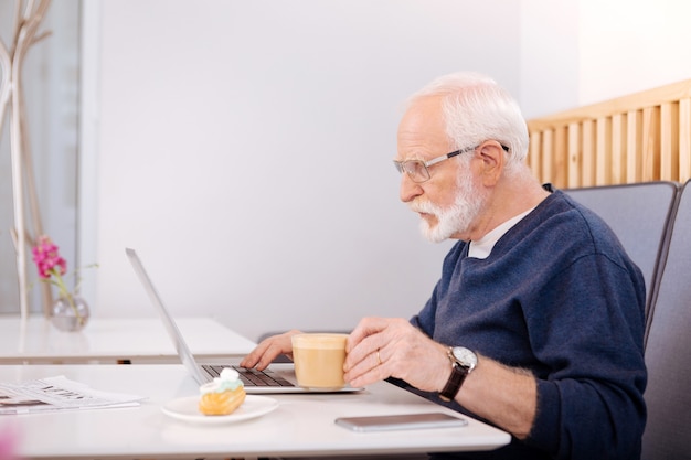 . freelancer sênior de ônibus usando laptop e posando em perfil