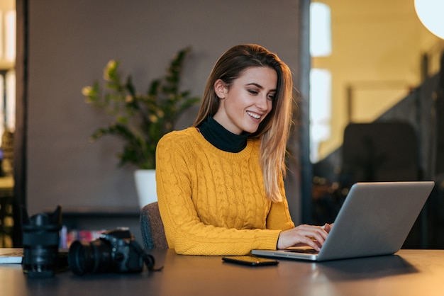 Freelancer sorridente trabalhando no laptop.