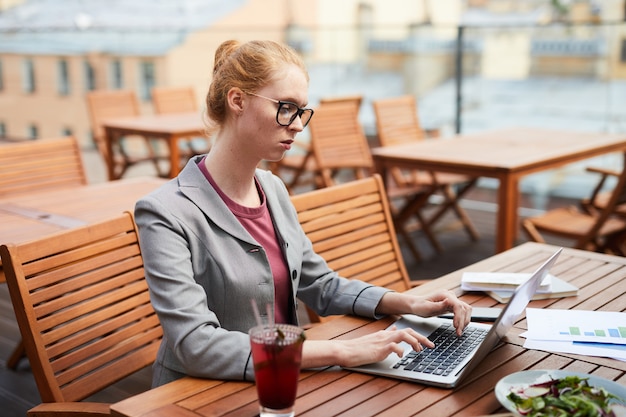 Freelancer trabajando en laptop en cafe