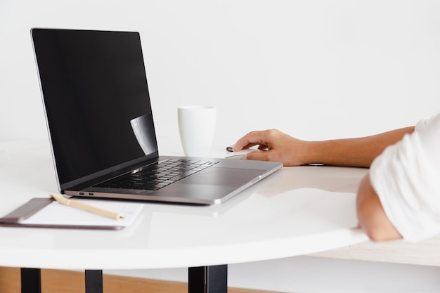 Freelancer trabalhando no laptop na mesa dentro de casa