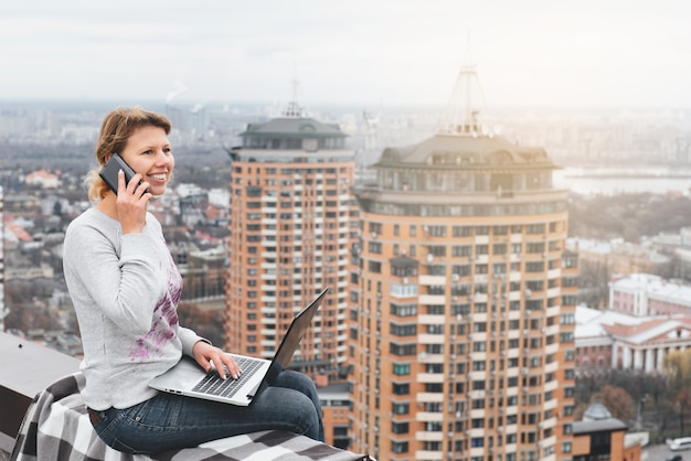 Freelancer trabalhando no telhado de um arranha-céu