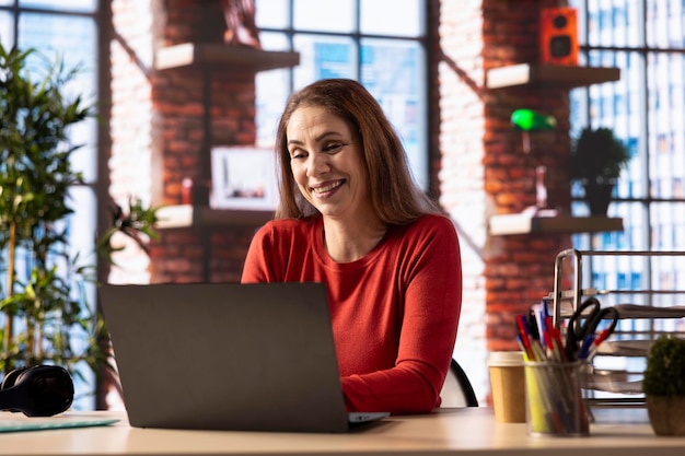 Freelancerin, die ihre kreativen Projekte aus der Ferne in ihrem Loft verwaltet