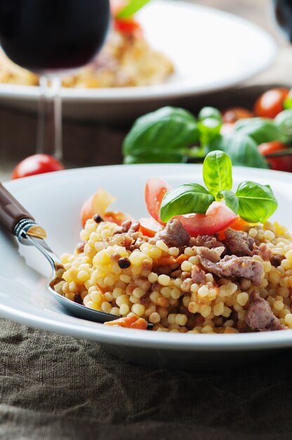 Fregola de pasta de sardinaina cocida con tomate y chorizo