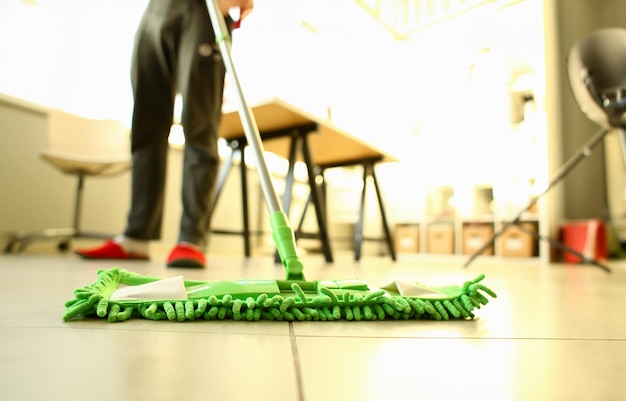 Fregona de plástico verde limpieza suelo laminado ligero sucio primer plano