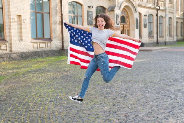 Frei sein und das Leben in vollen Zügen genießen. Glückliches Mädchen, das mit amerikanischer Flagge im Freien frei springt. Sinnliche Frau, die Freiheit und Unabhängigkeit feiert. Gewissensrechte und Willensfreiheit. Frei und unabhängig.