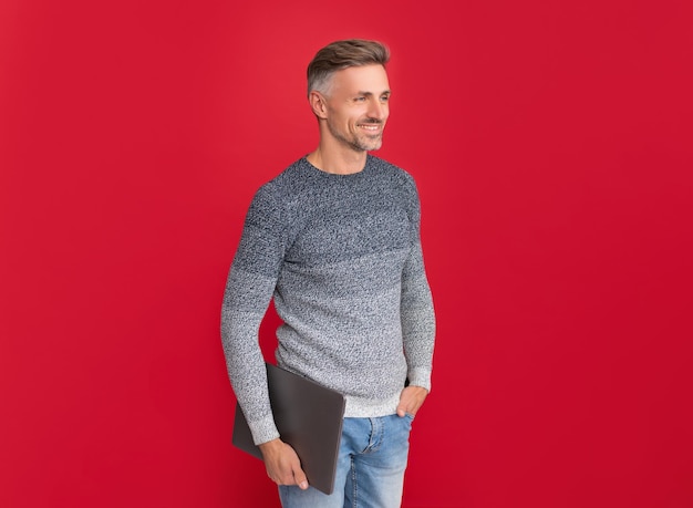 Freiberufler der modernen Technologie glücklicher grizzled Kerl im Pullover auf rotem Hintergrund