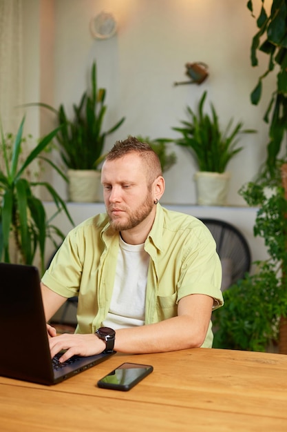 Freiberufler, der zu Hause mit Laptop auf dem Tisch arbeitet