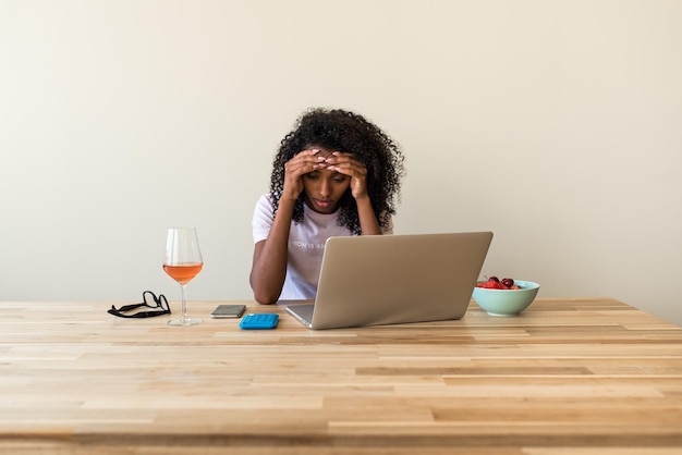 Freiberuflerin der Afroamerikaner mit Laptop zu Hause