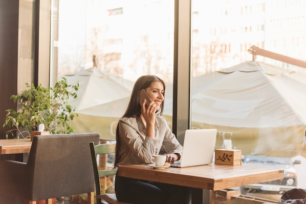 Foto freiberuflich tätige frau, die mit laptop in der kaffeestube arbeitet